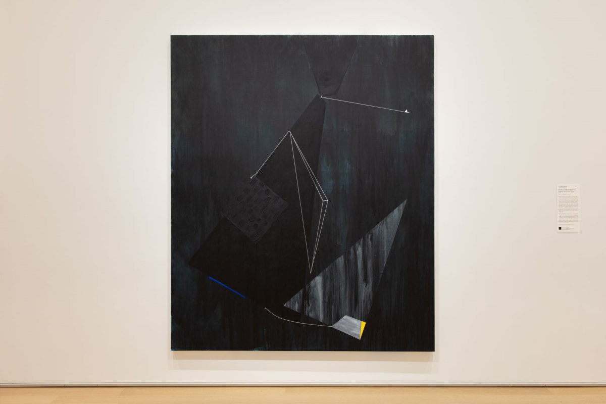 Large painting with geometric shapes in varied dark hues of wp:meta_valuek animagealtd white, blue, and yellow shapes and lines hangs on a white wall.