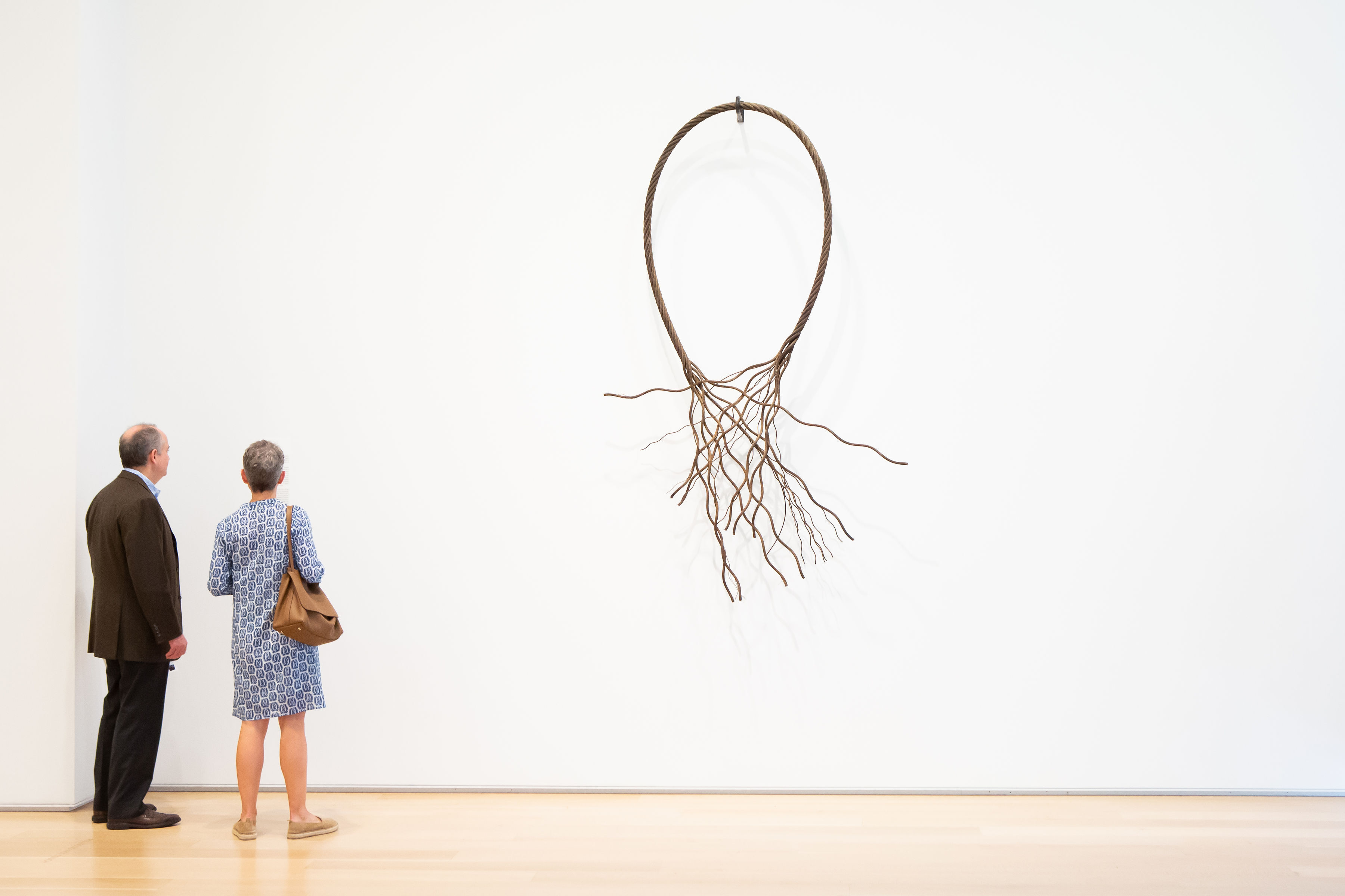 SCA members view artist Maren Hassinger's artwork on a white gallery wall.