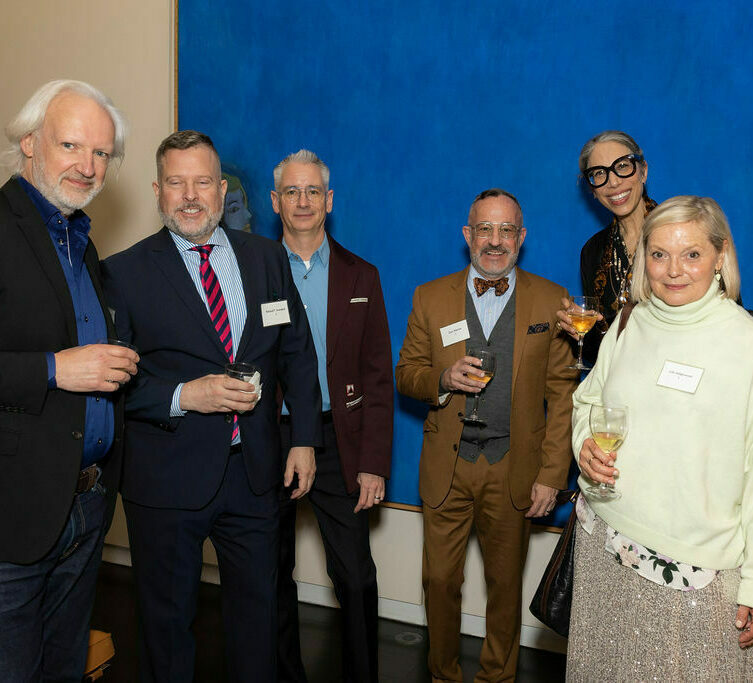 a group stands in front of a blue painting