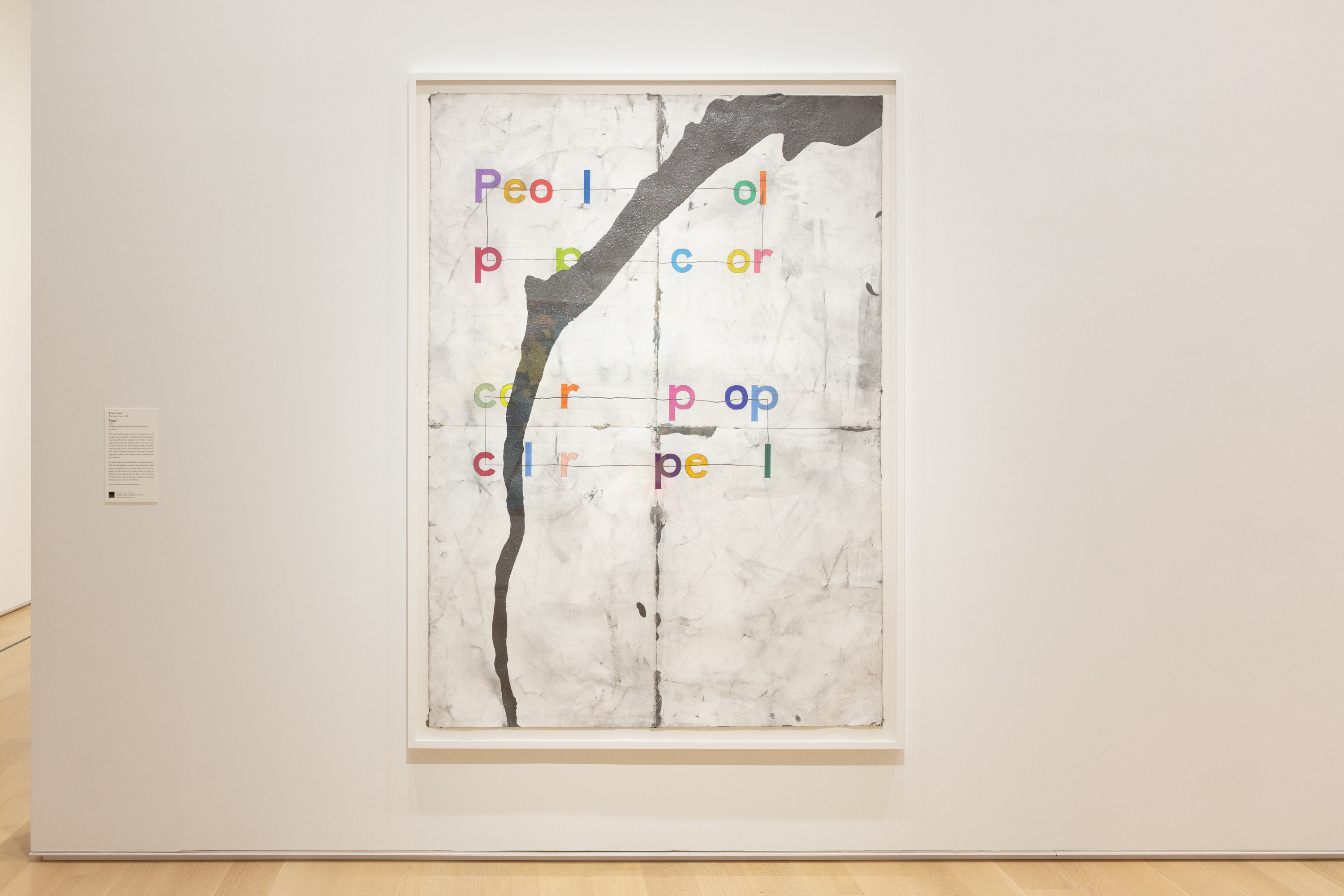 A large graphite and colored pencil drawing with a white frame hangs on a white wall.