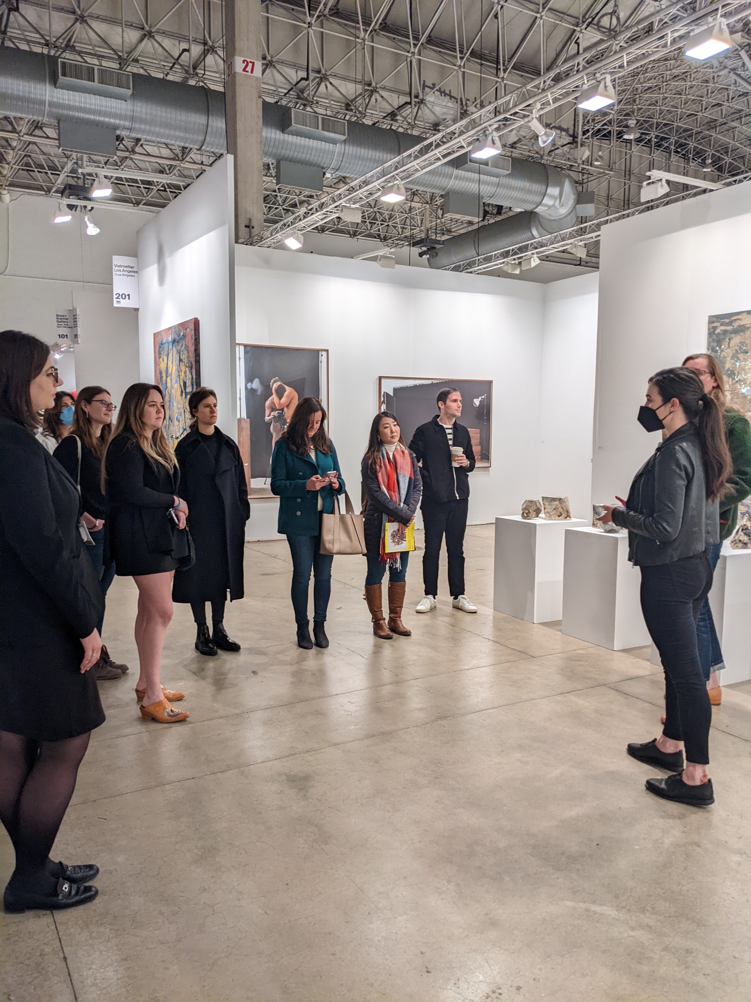 A group of people stand in a gallery space.